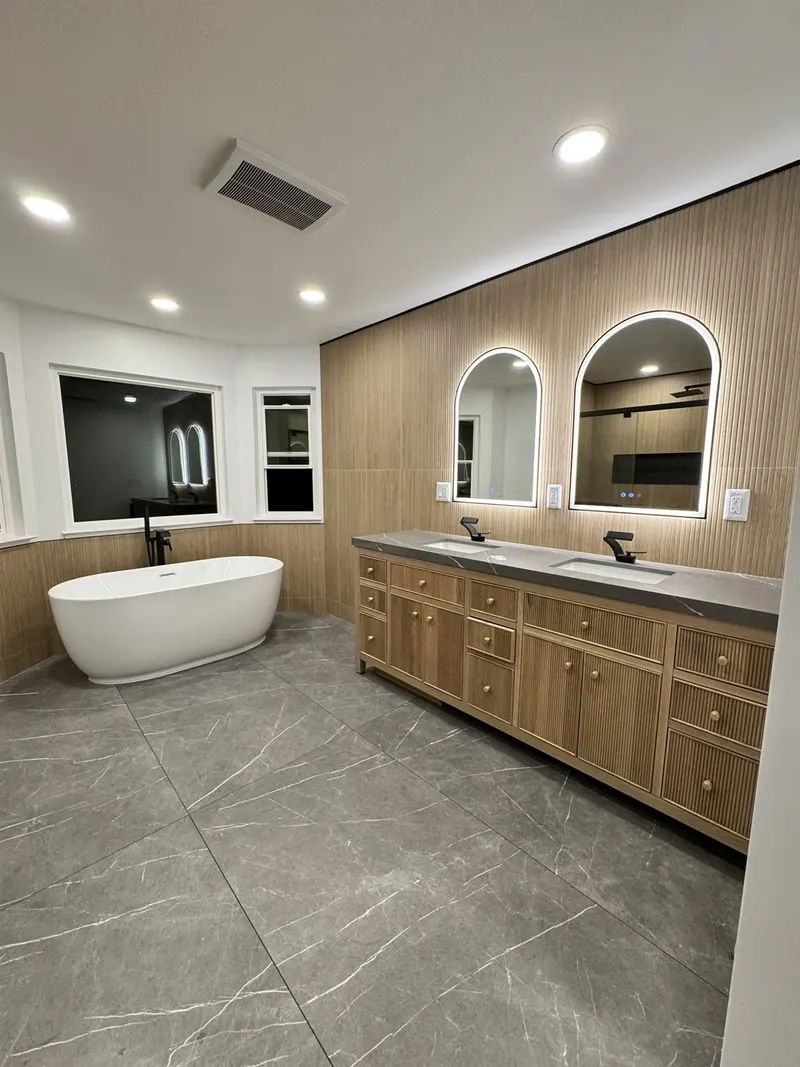 Remodeled bathroom with freestanding tub and white-oak double vanity