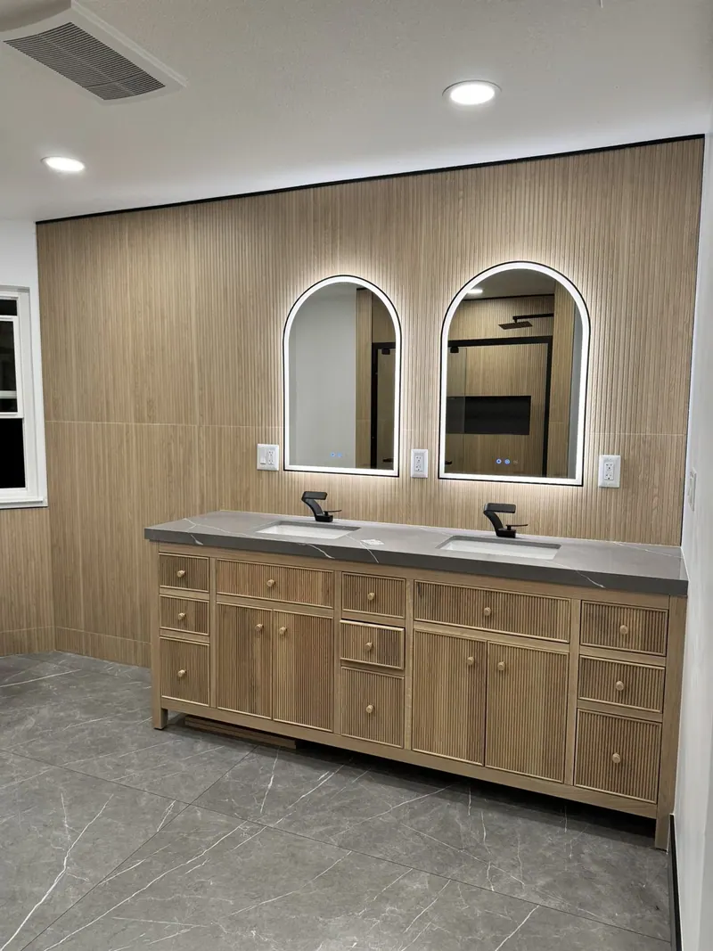 White-oak double vanity with arched backlit mirrors