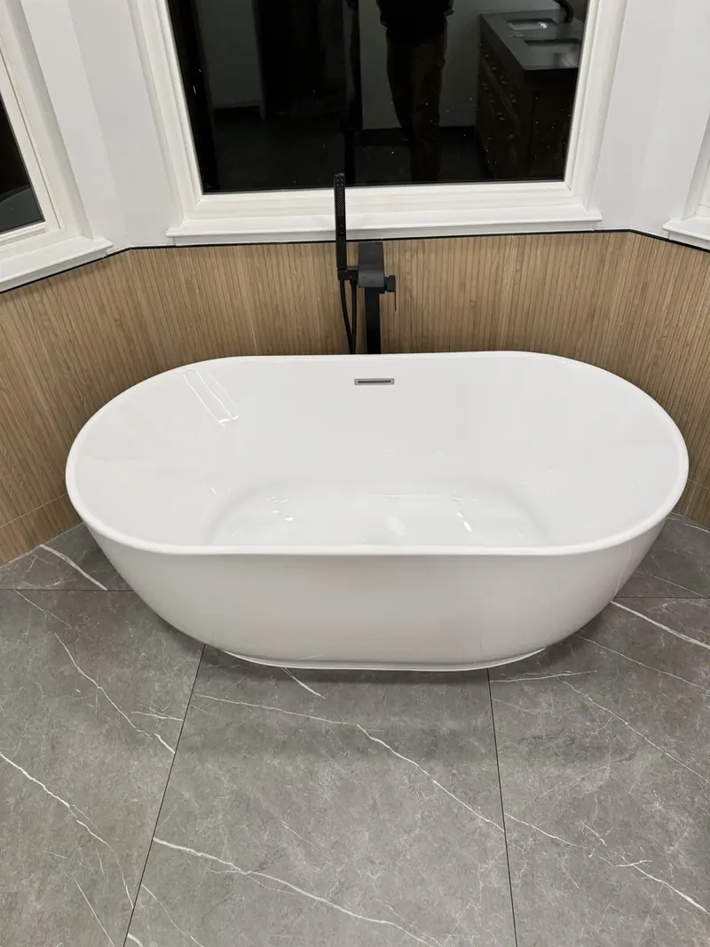 Remodeled bathroom with freestanding tub, oak double vanity and grey porcelain floor
