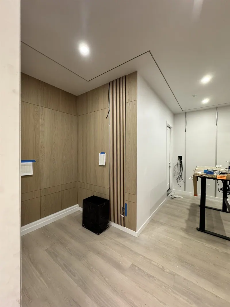 Home office with white-oak slat wall panels and an LED ceiling outline